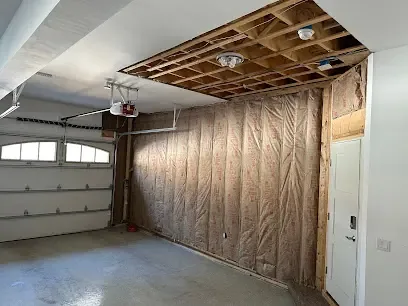 Garage ceiling opened to the joists with the wall insulation exposed so the cavity can dry