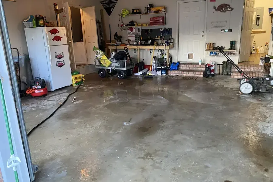 Garage floor still wet after the water was pushed out through the open door