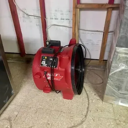 An air mover running in a room being dried out after a water leak at home